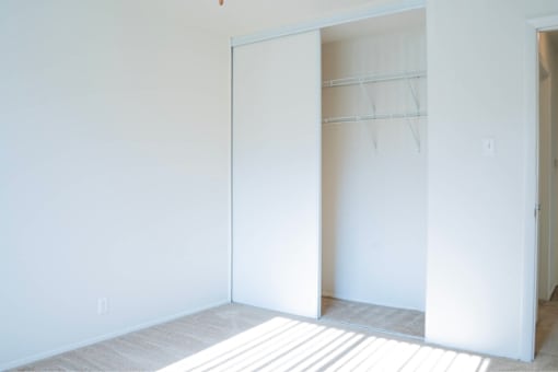 A white room with a door open to another room.