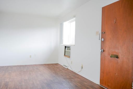 A room with a brown door and a window.