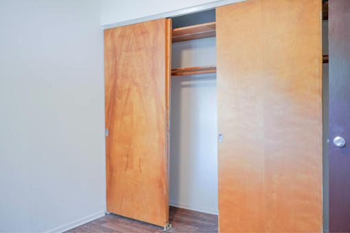 A wooden door is open to a hallway.