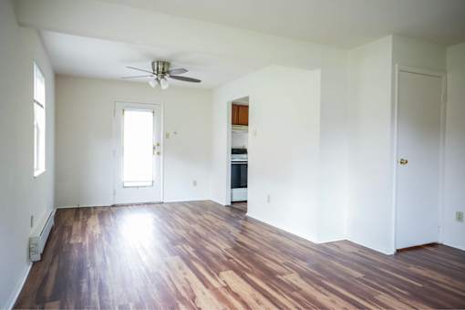 A room with wooden floors and a ceiling fan.