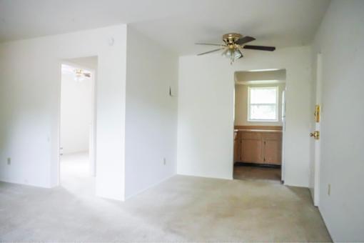 A room with a ceiling fan and a window.