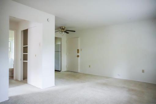 A white room with a ceiling fan and a door.