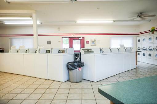 A white reception desk with a trash can in front of it.