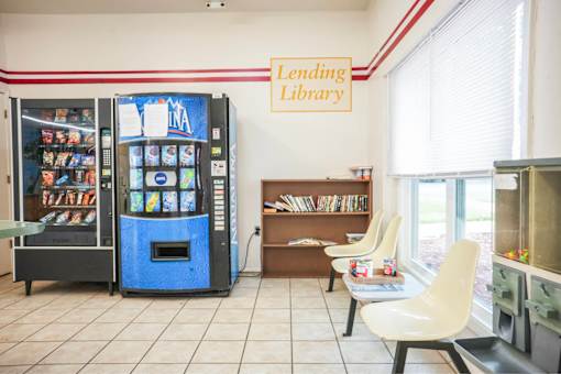 A Lending Library sign is above a book vending machine.