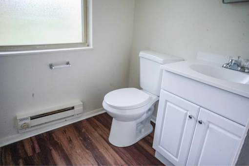 A white toilet and sink in a small bathroom.