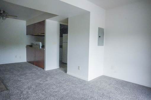 A room with a ceiling fan and a doorway leading to another room.