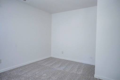 A room with white walls and carpeted floor.
