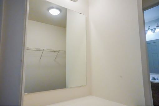 A bathroom with a mirror and a light on the ceiling.