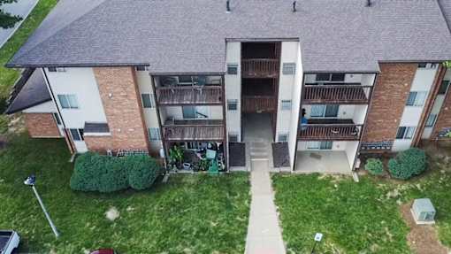 A large apartment complex with a grassy courtyard in the front.