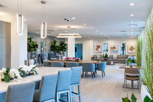 A modern office space with grey chairs and a long table.