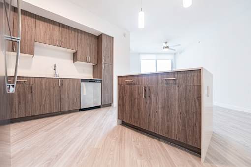 A kitchen with wooden cabinets and a white wall.