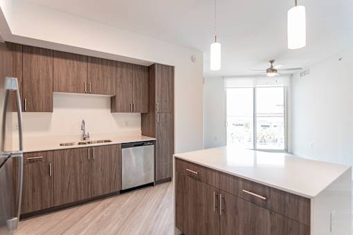 A kitchen with brown cabinets and a white counter.