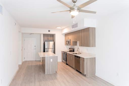 A modern kitchen with a ceiling fan and stainless steel appliances.