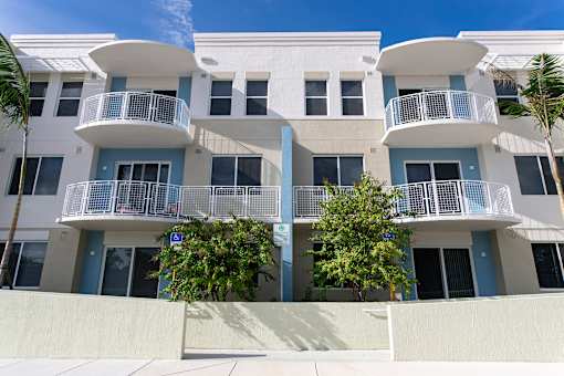 A white building with blue trim and balconies.