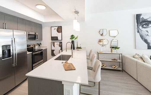 A modern kitchen with a white island and stainless steel appliances.