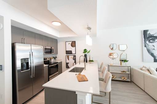 A modern kitchen with a refrigerator, oven, and sink.