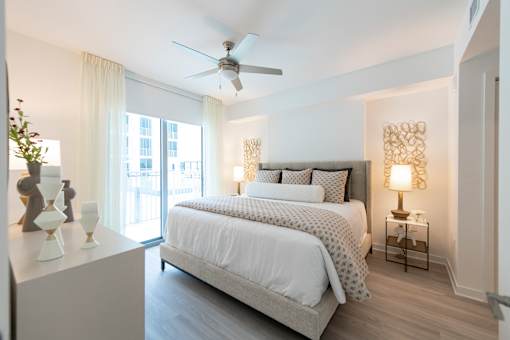 A bedroom with a large bed and a ceiling fan.