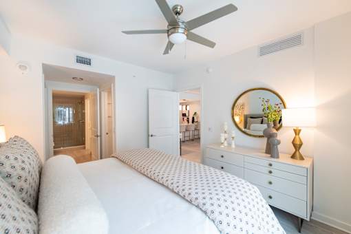 A bedroom with a bed, dresser, and mirror.