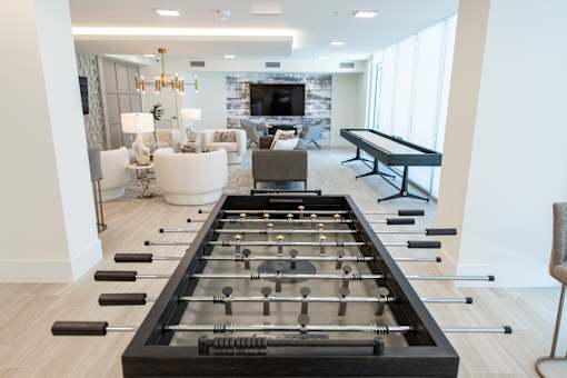 A foosball table is in the middle of a living room.