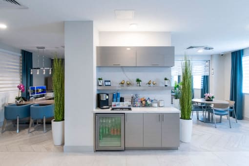 a modern kitchen and dining room with blue chairs and a table