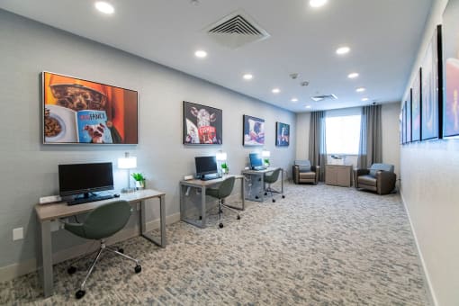 a large room with three computers and chairs in it