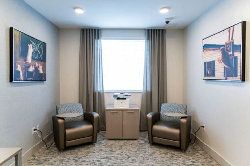a room with two chairs and a table in front of a window