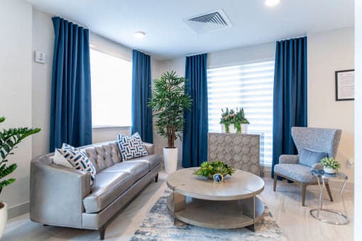 a living room with blue curtains and a couch and a table