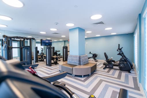 a gym with exercise machines and weights in a building with blue walls