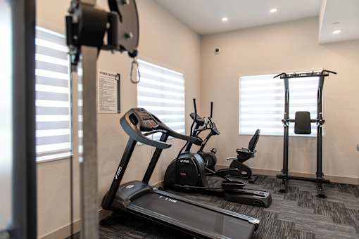 A gym with treadmills, exercise bikes, and a weight machine.