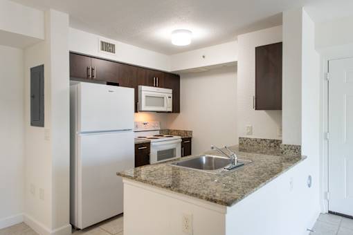 A kitchen with a granite counter top and stainless steel appliances.