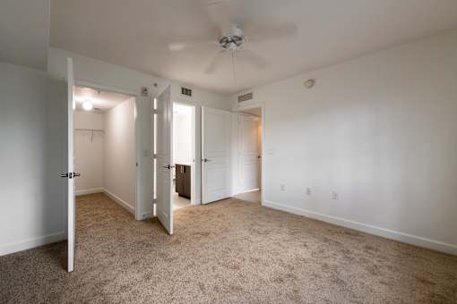 A room with a ceiling fan and carpeted floor.