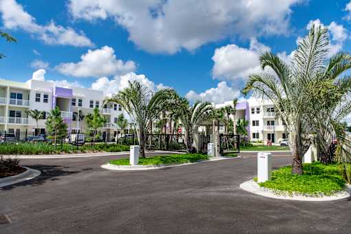 A sunny day at a residential complex with a paved courtyard.
