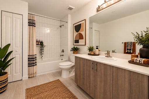 A bathroom with a toilet, sink, and a mirror.