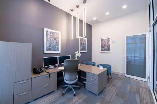 a conference room with a desk and two computer monitors