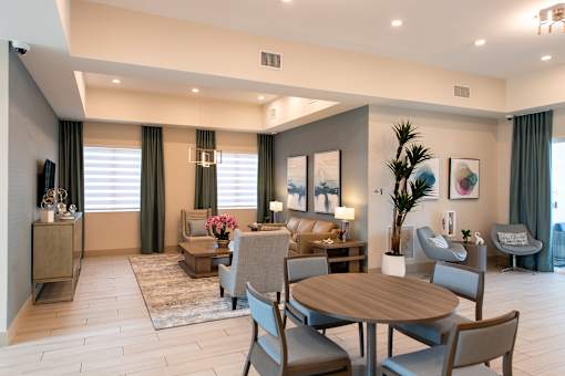 A well-lit living room with a dining table and chairs.