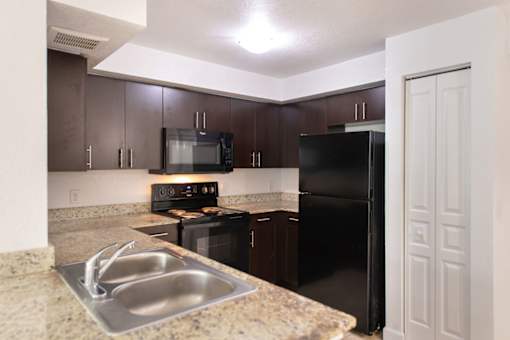 A kitchen with a black refrigerator and stove.