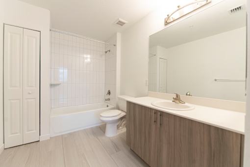 A white bathroom with a toilet, sink, and bathtub.