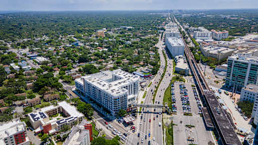 A highway with cars on it and buildings on the side.