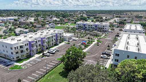 A parking lot is surrounded by apartment buildings.