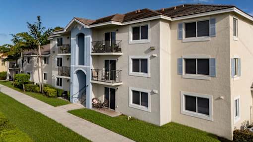 A row of apartment buildings with balconies and a clear blue sky.