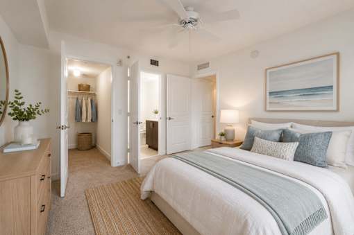 A bedroom with a large bed and a ceiling fan.