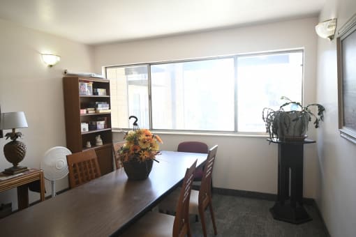 a dining room with a wooden table and chairs and a large window