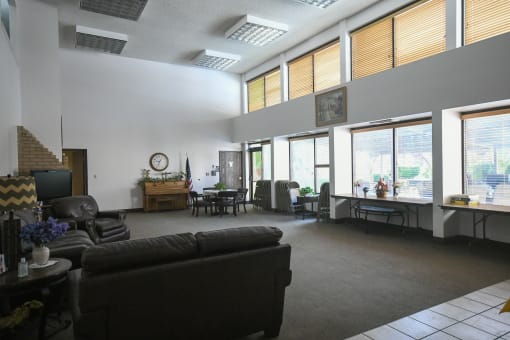 an open living room with couches and chairs and large windows