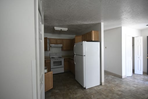 an empty kitchen with a refrigerator and a stove in it