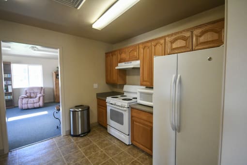 a kitchen with white appliances and wooden cabinets and a refrigerator