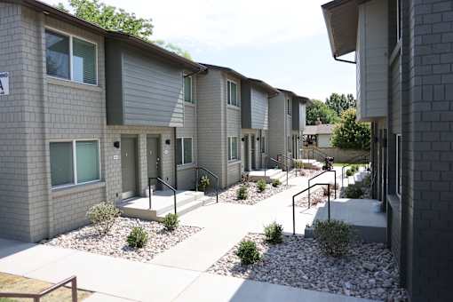 A row of modern townhouses with grey siding and white trim.