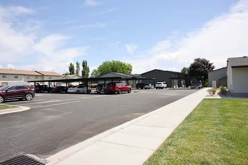 A parking lot with cars and a building in the background.