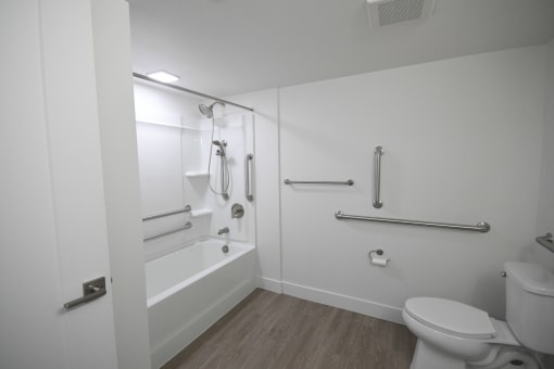a white bathroom with a toilet and a tub and a sink