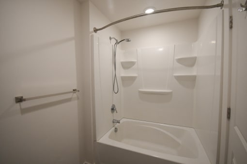 a white bathroom with a shower and a toilet