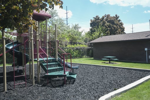 a playground with a slide and a picnic table